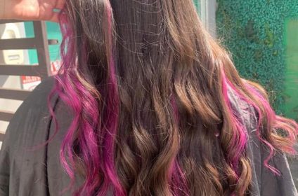 Técnica de colorimetría avanzada con mechas de fantasía en tono fucsia magenta vibrante sobre cabello oscuro en MQ Salon & Esthetic Arroyo PR.