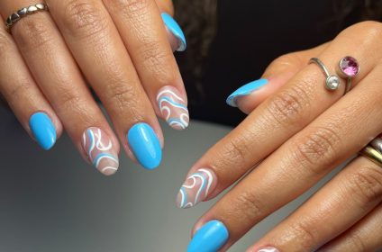 Uñas largas con Gel Tips en tono azul brillante y patrones abstractos blancos en Trend Nails Carolina.