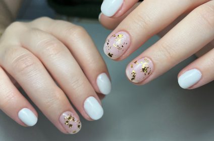 Uñas en Gel Tips de color blanco combinadas con acentos de hojuelas doradas en Trend Nails Carolina.