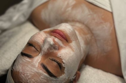 Aplicación de mascarilla facial y cuello en tratamiento de limpieza profunda en NO FILTER Skin & Beauty Gurabo PR.