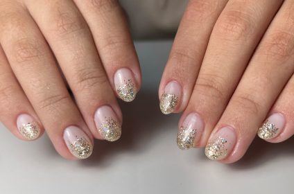 Uñas con diseño de degradado en glitter dorado sobre base natural en Trend Nails Carolina.