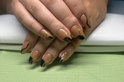 Aplicación de GelTips en tono nude con diseño de líneas abstractas en negro y dorado por Nails G Studio en Carolina.