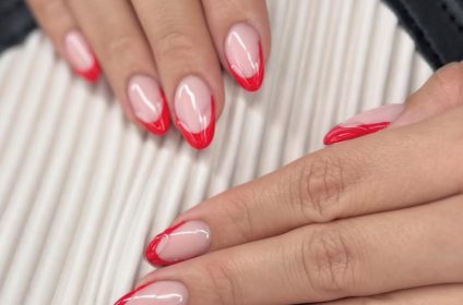 Diseño de uñas acrílicas medianas (medium acrylic nails) con manicura francesa en tono rojo brillante en Karla’s Beauty Salon Rincón PR.
