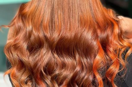 Trabajo de colorimetría con tinte de cabello cobrizo cálido e intenso y peinado en ondas definidas en MQ Salon & Esthetic Arroyo PR.